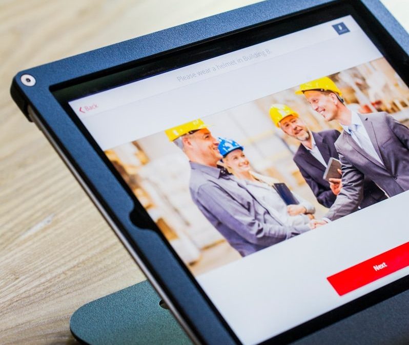 iPad with four business persons shaking hands display